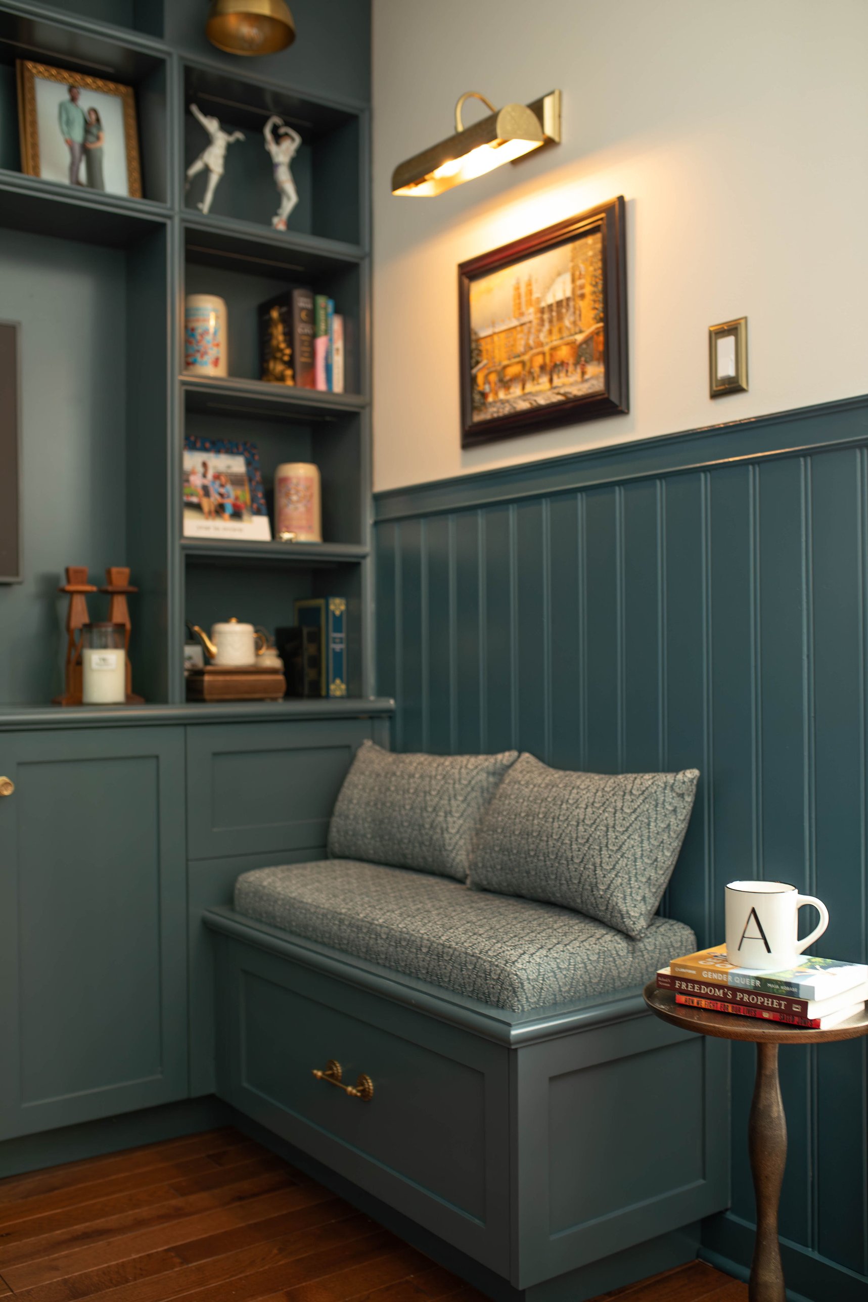 Custom built-in banquette with picture-lit art in a K&B Interiors home
